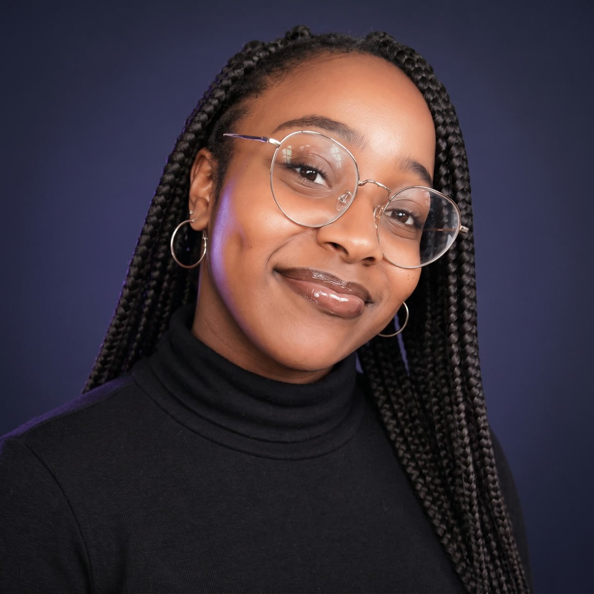 Linda Gitau, smiling, in a black turtleneck.